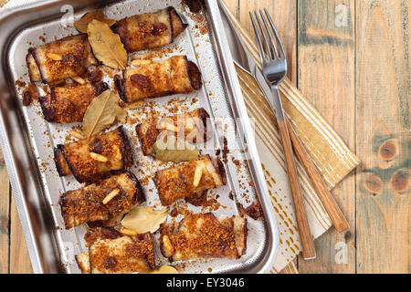 Baked eggplant rolls stuffed with nuts, raisins and cheese. Stock Photo