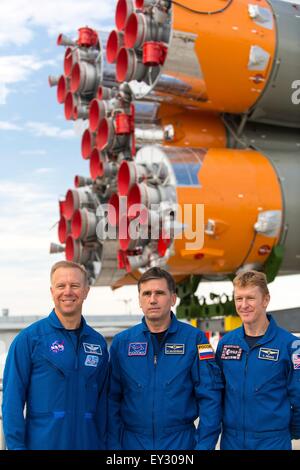 Baikonur Cosmodrome, Kazakhstan. 20th July, 2015. International Space Station Expedition 44 backup crew members Timothy Kopra of NASA, left; Yuri Malenchenko of the Russian Federal Space Agency, center; and Timothy Peake of the European Space Agency, right, pose for photos as the Soyuz TMA-17M spacecraft is rolled out by train to the launch pad at the Baikonur Cosmodrome July 20, 2015 in Kazakhstan. Launch of the Soyuz rocket is scheduled for July 23 and will carry Expedition 44 crew to the International Space Station. Stock Photo