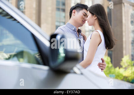 Young couple kissing next to their car Stock Photo