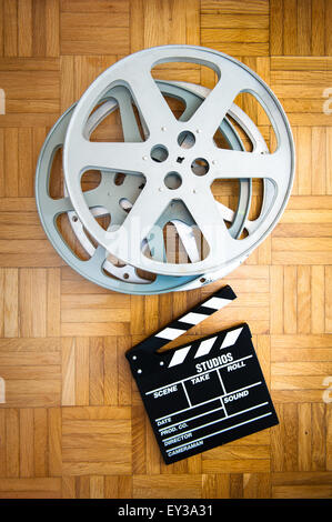 Movie Clapper And Film Reel On A Wooden Background Stock Photo, Picture and  Royalty Free Image. Image 128026353.