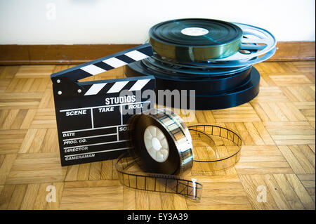 35 mm cinema movie clapper board and film reels in background on wooden floor Stock Photo