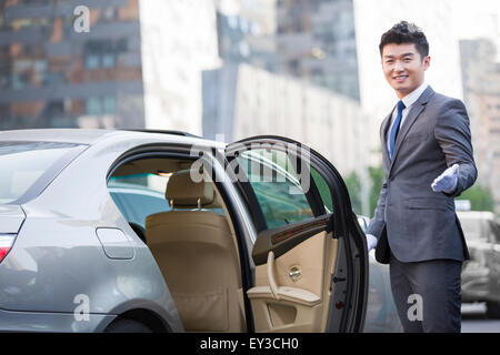 Chauffeur opening car door Stock Photo