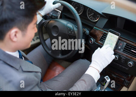 Chauffeur using smart phone as gps navigation for car Stock Photo
