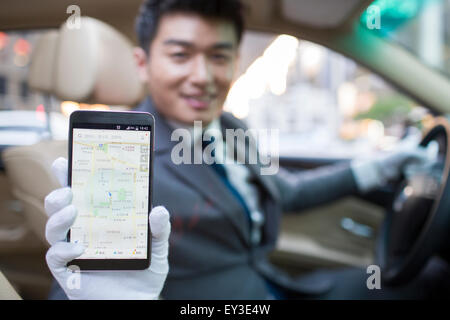 Chauffeur using smart phone as gps navigation for car Stock Photo