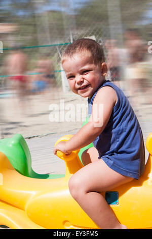 child to the playground on a rocking horse Stock Photo
