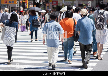 Tokyo, Japan. 21st July, 2015. Pedestrians hold parasols to get some shade in the hot weather in Shinjuku district on July 21, 2015, Tokyo, Japan. The Japan Meteorological Agency announced on Sunday that they believe the annual rainy season is over 2 days earlier than usual in the Tokyo region. Credit:  Rodrigo Reyes Marin/AFLO/Alamy Live News Stock Photo