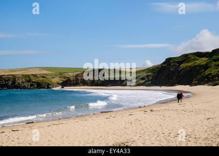 A quiet sandy beach known as Whistling Sands on Lleyn Peninsula / Pen Llyn with two people walking at Porth Oer Gwynedd north Wales UK Britain Stock Photo