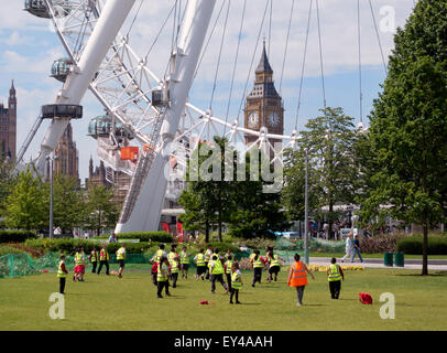 Children playing football outdoors in the Jubilee gardens, South bank, by the London Eye, Big Ben in the background, London UK Stock Photo