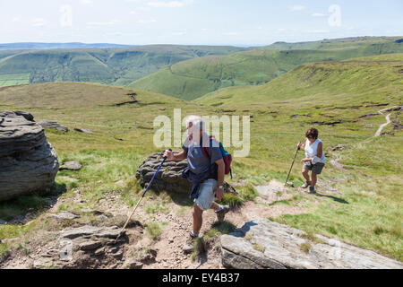 Hill walkers in the English countryside during Summer walking up Grindslow Knoll on Kinder Scout, Derbyshire, Peak District National Park, England, UK Stock Photo