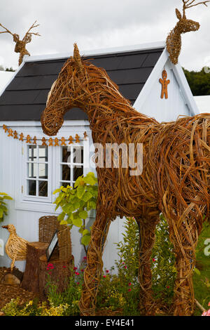 Tatton Park, Cheshire, UK 21st July, 2015. Lattice, Wickerwork, plaited or woven twigs or osiers, woven wicker horse , sculptures brown, design, pattern, wooden funny shed at the RHS Flower Show. Stock Photo