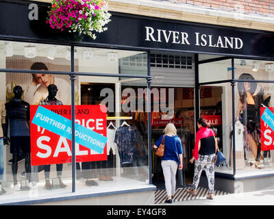 Two younger women enter the River Island shop in the High Street, Winchester, Hampshire possibly attracted by the Sale. Stock Photo