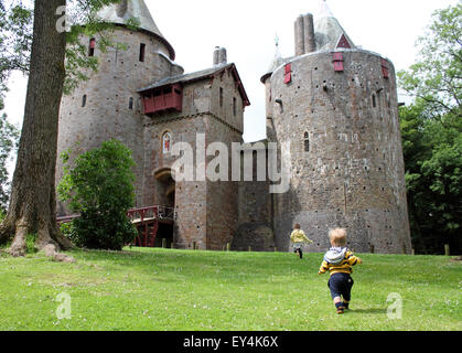 Young boy and girl running towards castle or Castell Coch, Cardiff, South Wales, UK Stock Photo