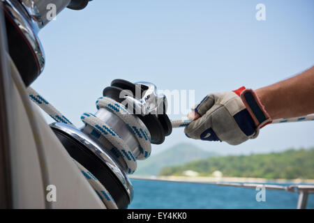 Winch and sailors hands on a sailboat. Shot with a selective focus Stock Photo