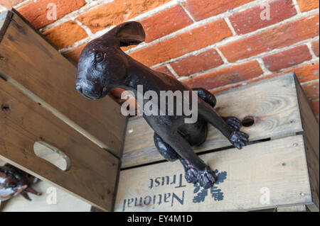 Black painted brass model of an Hare sitting on a National Trust wooden box. Stock Photo