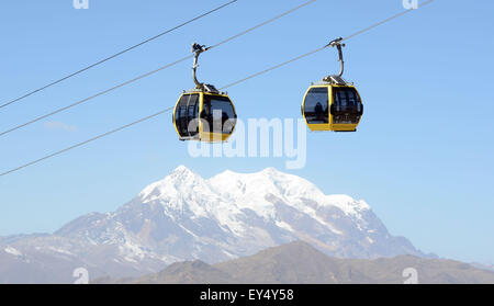 La Paz, Bolivia. 07th July, 2015. Bolivians use the yellow cable car line to make their way from El Alto, located at an altitude of 4,000 m above sea level, to the city centre of La Paz, Bolivia, 07 July 2015. Illimani, a local mountain of La Paz, is pictured in the background. Photo: Georg Ismar/dpa/Alamy Live News Stock Photo