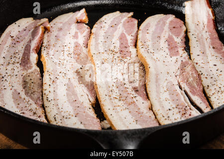 Strips of raw bacon in a skillet ready to be fried Stock Photo