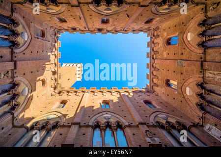 SIENA, ITALY - October 26, 2014: Wide angle view from courtyard of Torre del Mangia and Palazzo Pubblico in Siena, Italy. Stock Photo