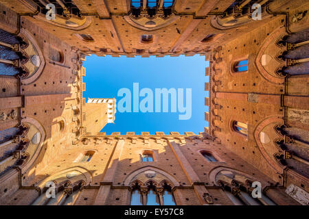 SIENA, ITALY - October 26, 2014: Wide angle view from courtyard of Torre del Mangia and Palazzo Pubblico in Siena, Italy. Stock Photo