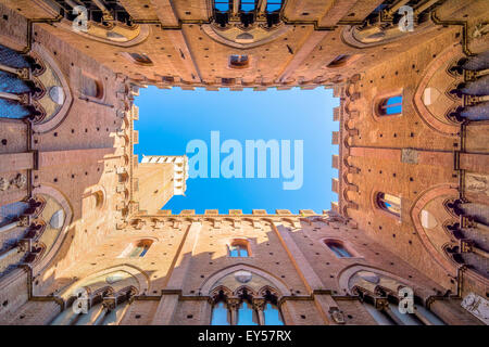 SIENA, ITALY - October 26, 2014: Wide angle view from courtyard of Torre del Mangia and Palazzo Pubblico in Siena, Italy. Stock Photo