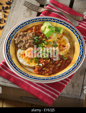 Huevos rancheros. Fried eggs on tortillas with tomato chilli sauce and refried beans Stock Photo