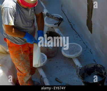 building worker cutting plastic grid for plaster worker Stock Photo
