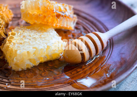 Honey in jar with honey dipper on vintage wooden background Stock Photo