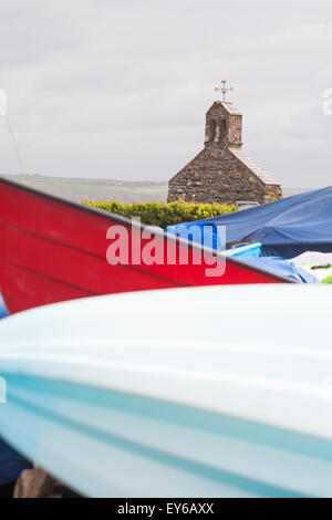 remains of church seen with shapes of boats in the foreground at Cwm yr Eglwys, Pembrokeshire Coast National Park, Wales UK in May Stock Photo