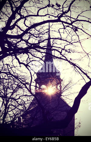 Vintage instagram filtered photo of mysterious or scary church bell tower silhouette at sunset. Stock Photo