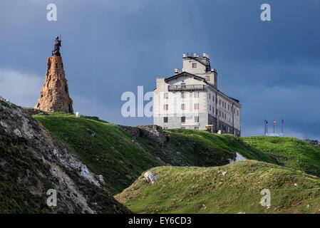 The Petit-Saint-Bernard hospice and statue of Saint Bernard de Menthon at the Little St Bernard Pass in the French Italian Alps Stock Photo