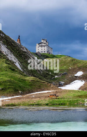 The Petit-Saint-Bernard hospice and statue of Saint Bernard de Menthon at the Little St Bernard Pass in the French Italian Alps Stock Photo