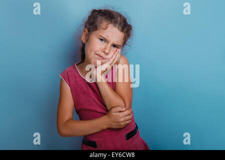 Girl European appearance decade toothache on a blue  background