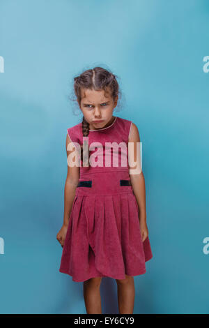 Girl European appearance decade angry frowns on blue background Stock Photo