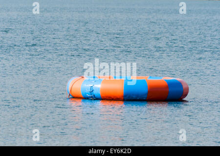 A blue and orange large inflatable ring in the sea at an outdoor activity centre Stock Photo