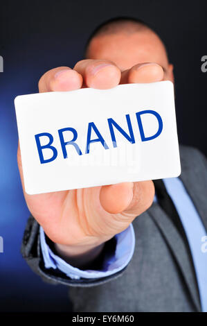 young caucasian man in suit shows a signboard with the word brand written in it Stock Photo