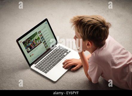 A Child watching Youtube videos on a laptop computer Stock Photo