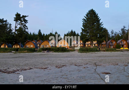Wood cabins of Ocean Village Resort in Tofino, BC, Canada, at sunset.  On Mackenzie Beach. Stock Photo