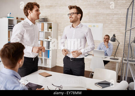 Happy architects sharing their ideas in working environment Stock Photo