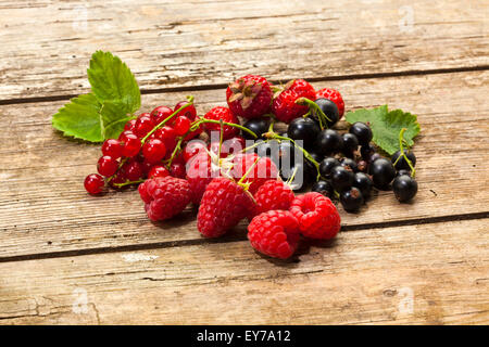 Assortment of fresh berry fruits on rustic wooden table Stock Photo