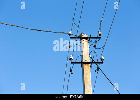 High-voltage electricity pylons against blue sky Stock Photo