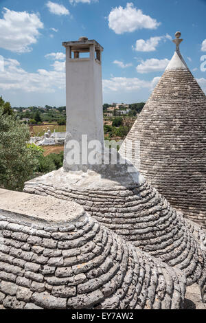 Looking across the conical stone roofs of trulli houses towards the countryside,  Locorotondo, in the Itria Valley, Pugli, Italy Stock Photo