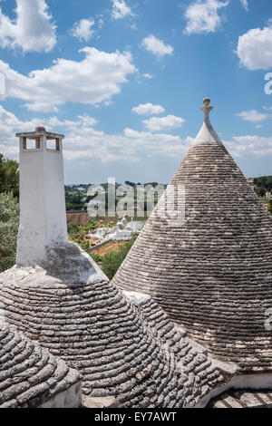 Looking across the conical stone roofs of trulli houses towards the countryside,  Locorotondo, in the Itria Valley, Pugli, Italy Stock Photo