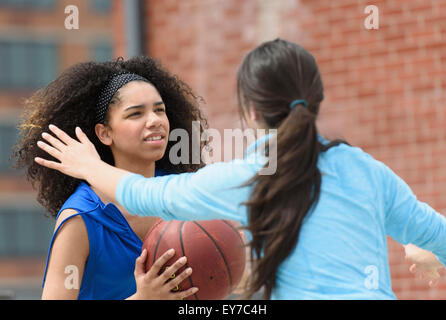Teenage girls (14-15, 16-17) playing basketball Stock Photo