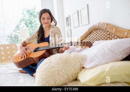 Teenage girl (14-15) playing guitar Stock Photo