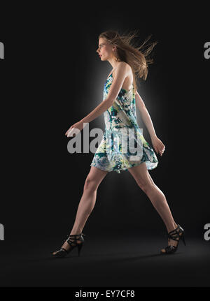 Studio shot of young woman walking Stock Photo
