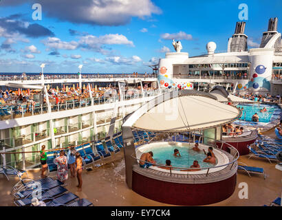 Caribbean Sea - Jan. 17, 2013: Passengers aboard Royal Caribbean's Oasis of the Seas enjoy the pool and sun on the Lido Deck.  T Stock Photo