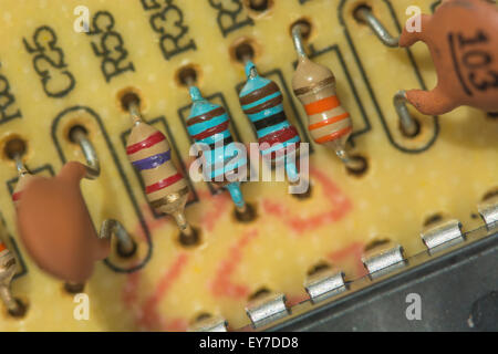 Macro-photo of resistors (carbon, and metal film [blue]) & capacitors on through-hole printed circuit board. Resistance concept, electrical resistance Stock Photo