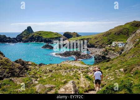 Kynance Cove, Cornwall with tourists walking down the path to the beach, Lizard Peninsula, West Cornwall, England, UK Stock Photo