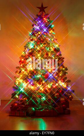 Christmas tree in dark, shot with cross screen filter, resulting large, cross shaped streaks Stock Photo
