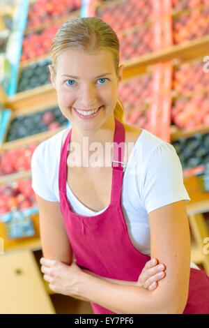 Smiling shop assistant in grocery store Stock Photo