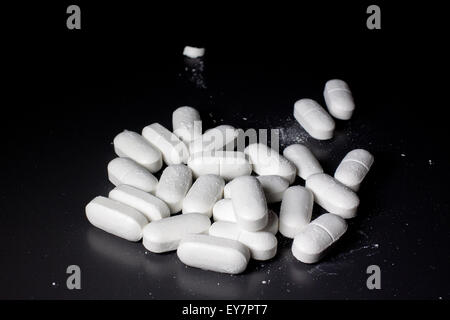 Pharmacy background on a black table. TTablets with a spoon. Pills ...